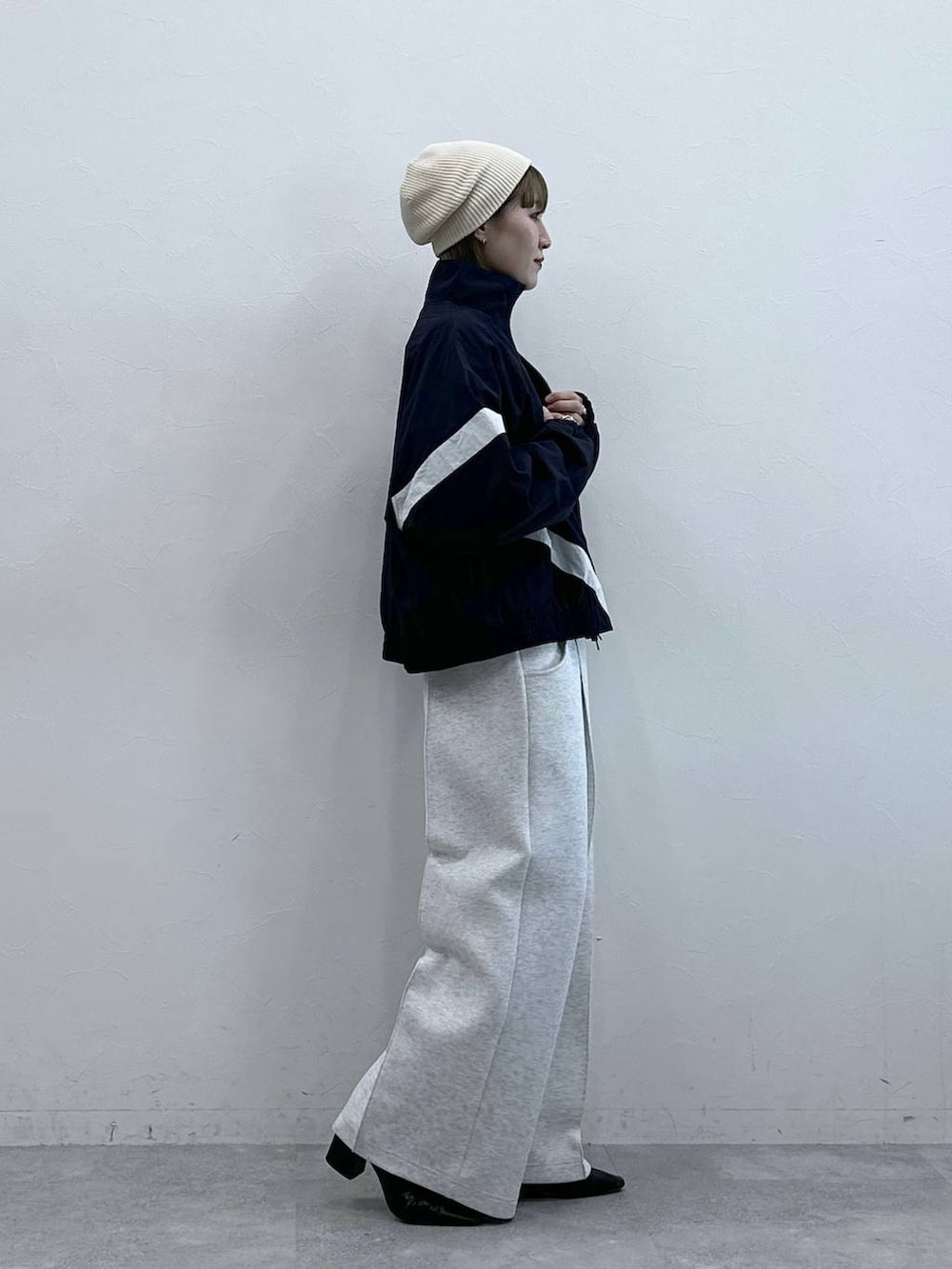 ホワイト系のスウェットパンツ、ブルー系のブルゾン、ホワイト系のTシャツ/カットソーを着用したレディースの冬コーディネートの6枚目の写真