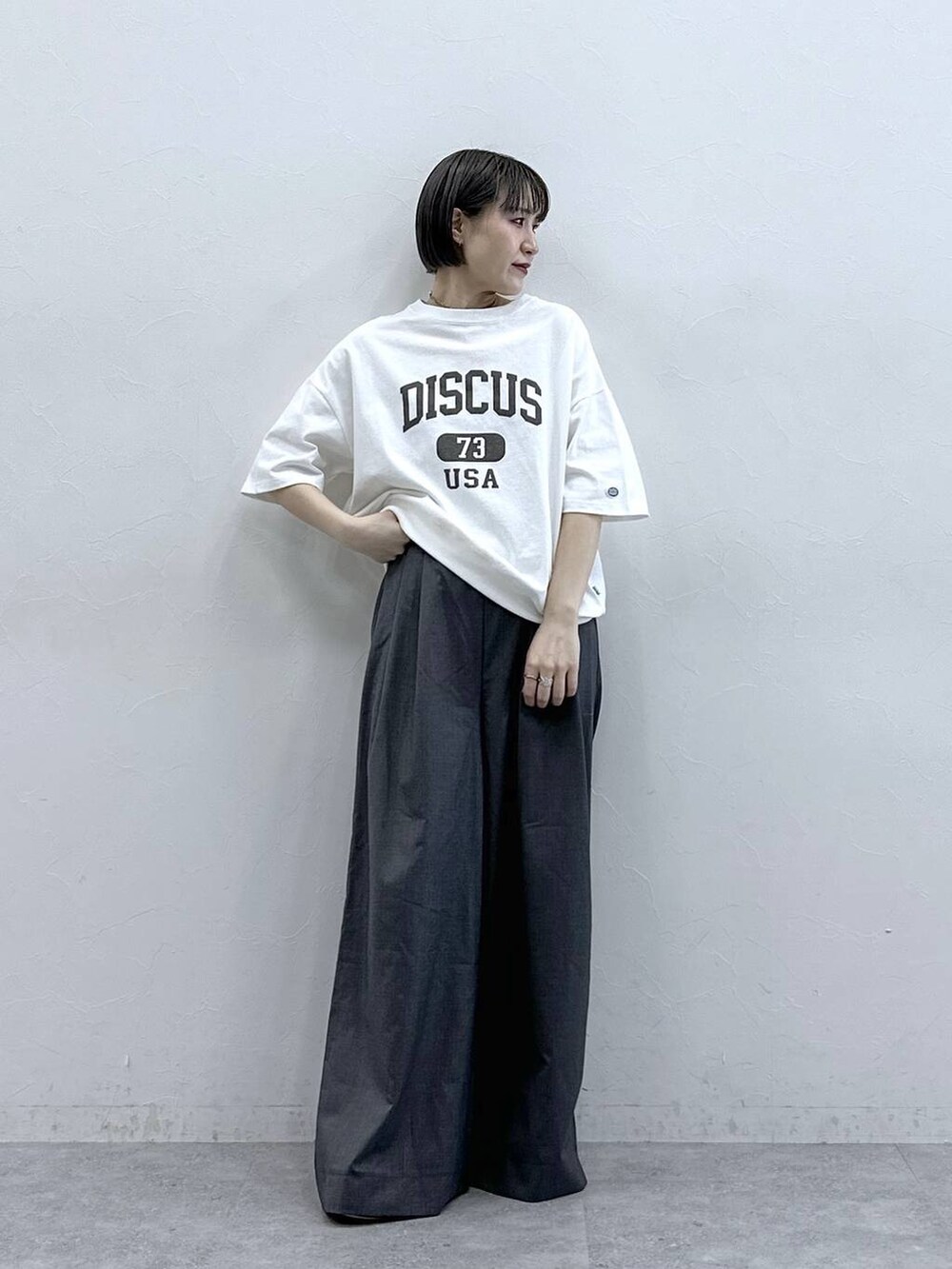 ホワイト系のTシャツ/カットソー、グレー系のスラックスを着用したレディースの春コーディネートの5枚目の写真