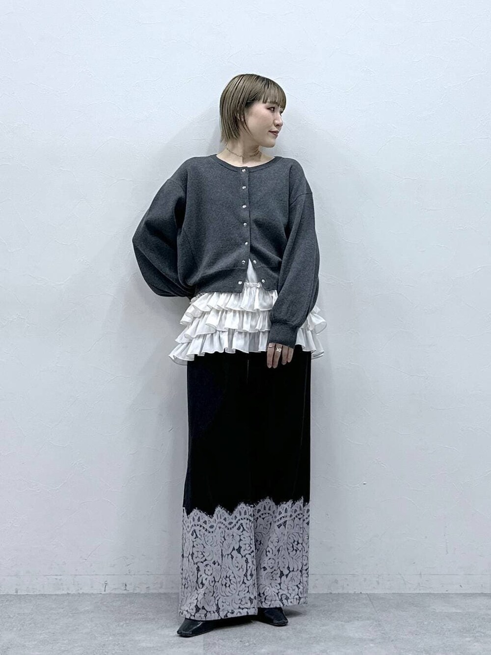 ホワイト系のキャミソール、グレー系のカーディガン/ボレロ、ブラック系のデニムパンツを着用したレディースの冬コーディネートの2枚目の写真