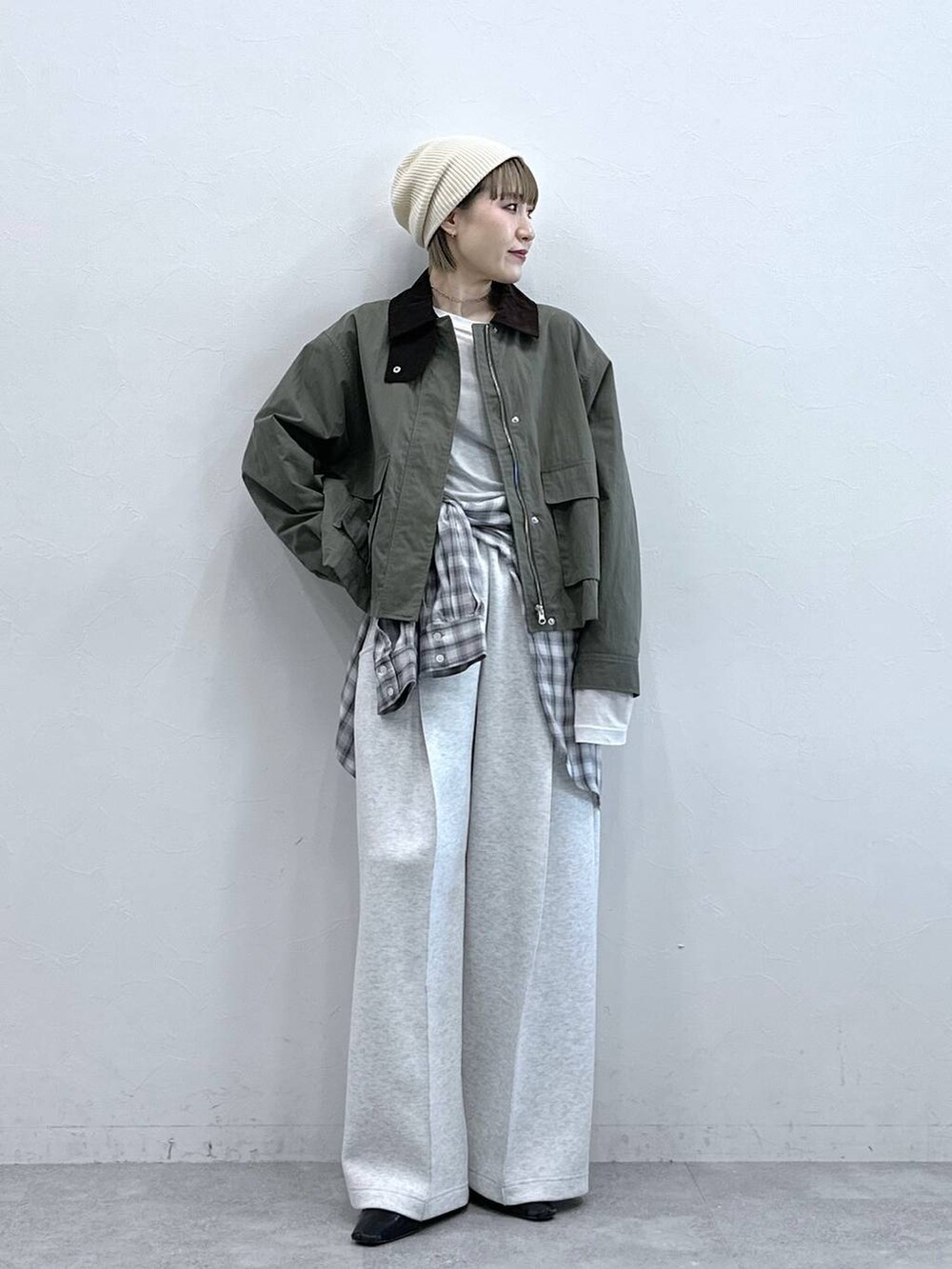 ホワイト系のスウェットパンツ、ブラック系のシャツ/ブラウス、グリーン系のブルゾンを着用したレディースの冬コーディネートの4枚目の写真