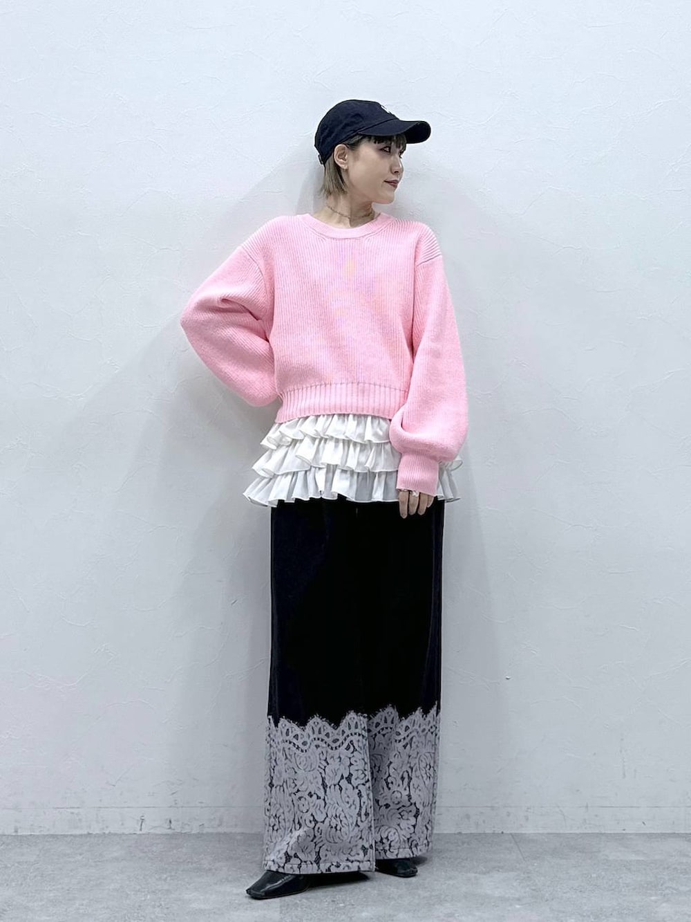 ホワイト系のキャミソール、ピンク系のニット/セーター、ブラック系のデニムパンツを着用したレディースの冬コーディネートの2枚目の写真