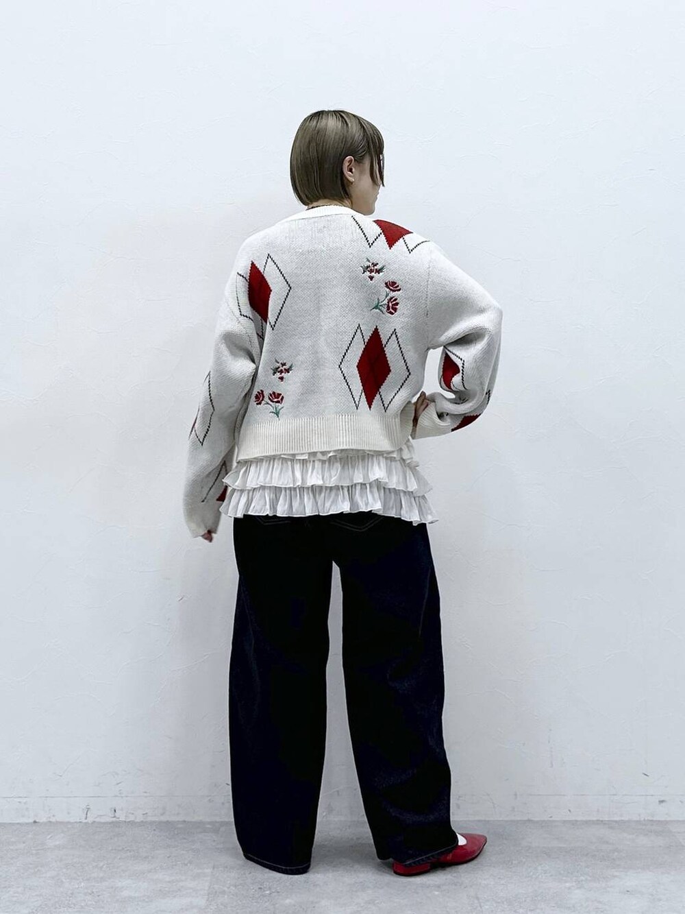 ホワイト系のキャミソール、レッド系のパンプス、ブラック系のデニムパンツを着用したレディースの冬コーディネートの5枚目の写真