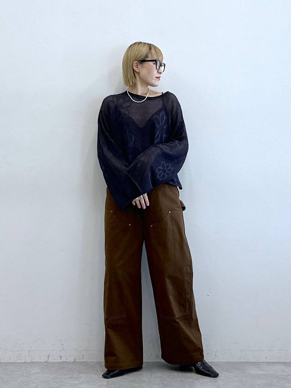 グレー系のニット/セーター、ブラウン系のチノパンツ、グレー系のメガネを着用したレディースの夏コーディネートの6枚目の写真