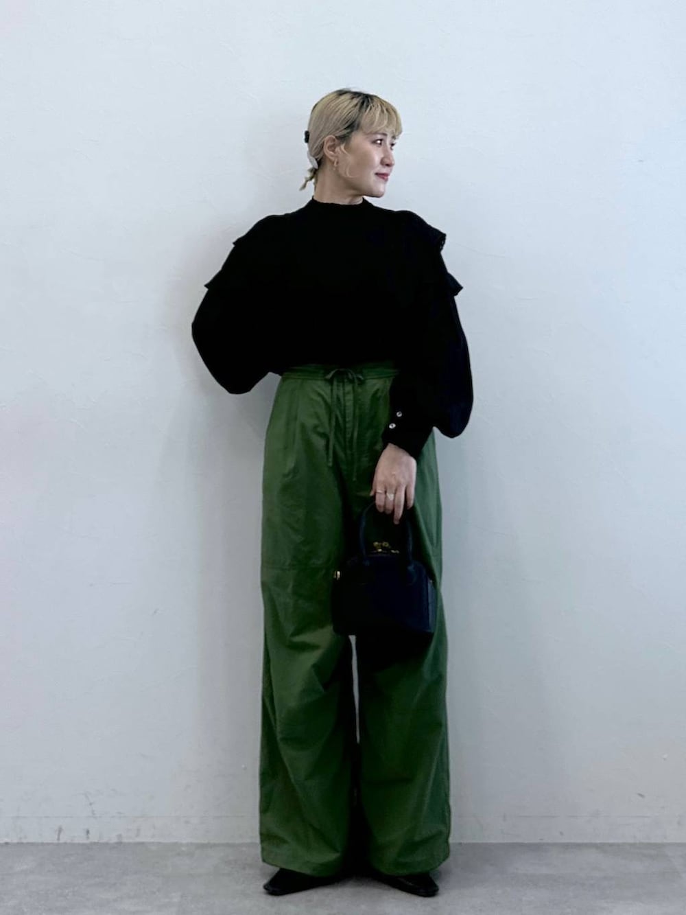 グリーン系のカーゴパンツ、ブラック系のシャツ/ブラウスを着用したレディースの秋コーディネートの3枚目の写真