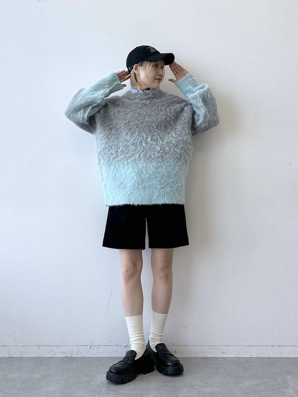 ブラック系のローファー、グレー系のニット/セーター、ブルー系のシャツ/ブラウスを着用したレディースの秋コーディネートの2枚目の写真