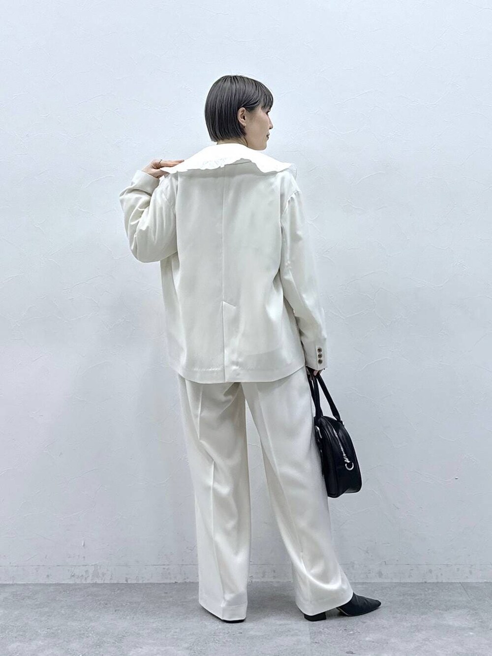 ホワイト系のシャツ/ブラウス、ブラック系のボストンバッグ、ホワイト系のテーラードジャケットを着用したレディースの春コーディネートの6枚目の写真