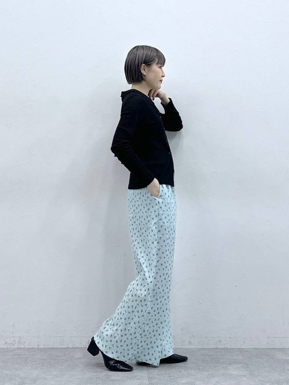 ブルー系のスラックス、ブラック系のカーディガン/ボレロを着用したレディースの春コーディネートの4枚目の写真