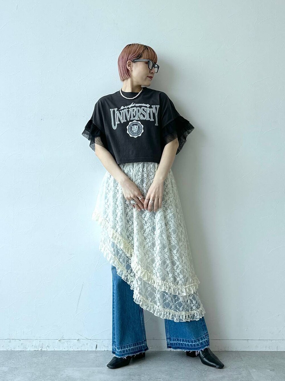 ブルー系のデニムパンツ、ホワイト系のスカート、ブラック系のTシャツ/カットソーを着用したレディースの春コーディネートの3枚目の写真