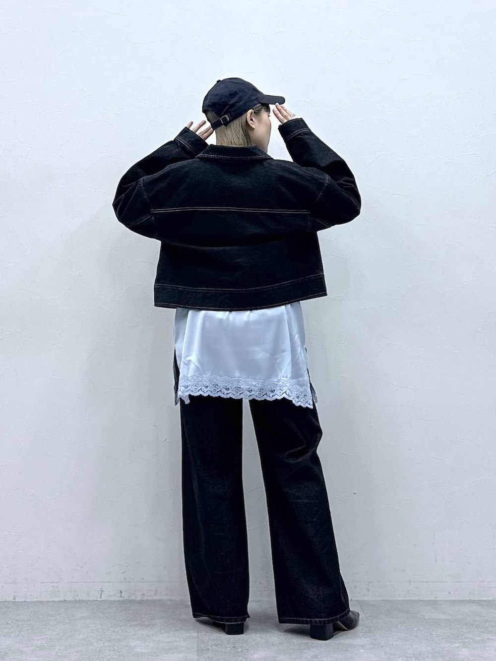 ブラック系のデニムジャケット、ブラック系のデニムパンツ、ブルー系のキャミソールを着用したレディースの冬コーディネートの5枚目の写真