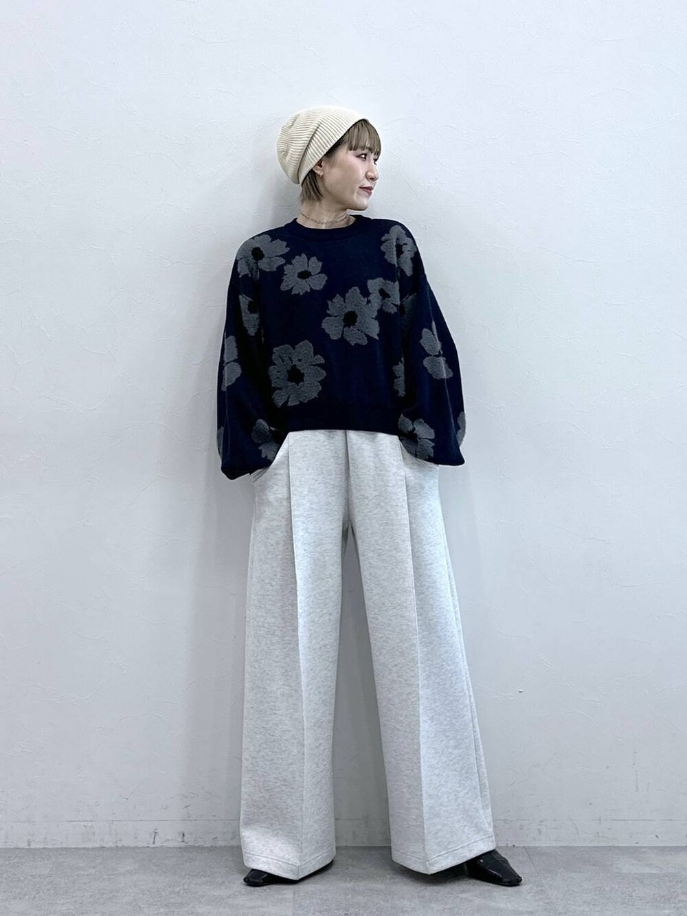 ホワイト系のスウェットパンツ、ブルー系のニット/セーター、ホワイト系のTシャツ/カットソーを着用したレディースの冬コーディネートの2枚目の写真