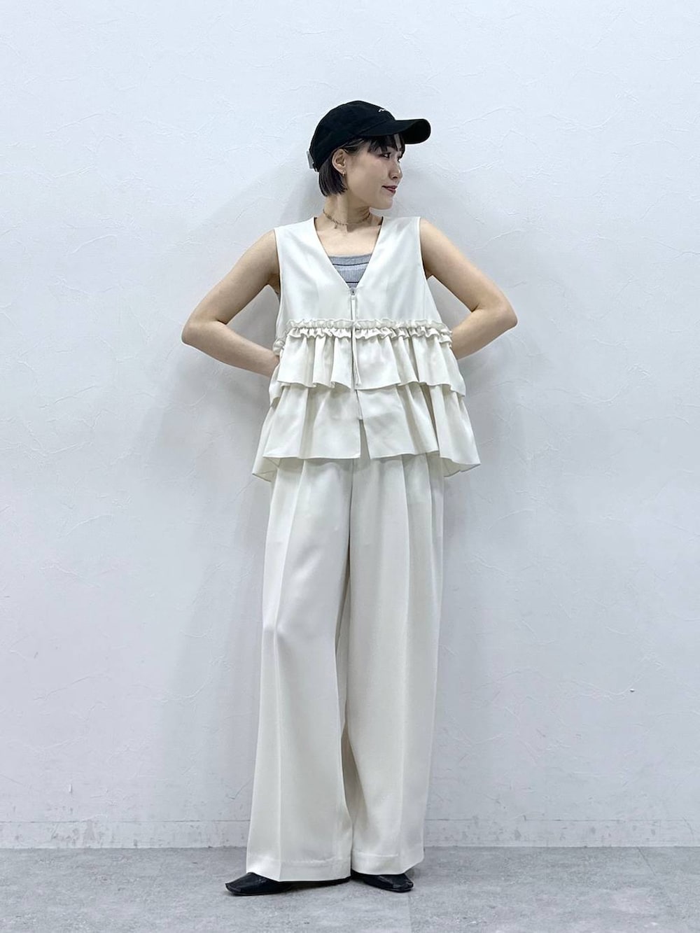 グレー系のタンクトップ、ブラック系のキャップを着用したレディースの春コーディネートの5枚目の写真