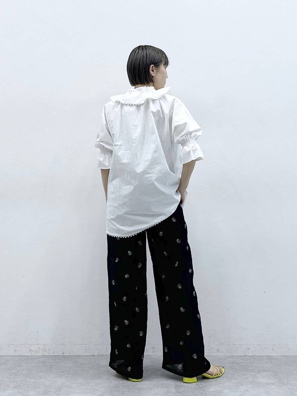 ブラック系のスラックス、ホワイト系のシャツ/ブラウスを着用したレディースの春コーディネートの5枚目の写真