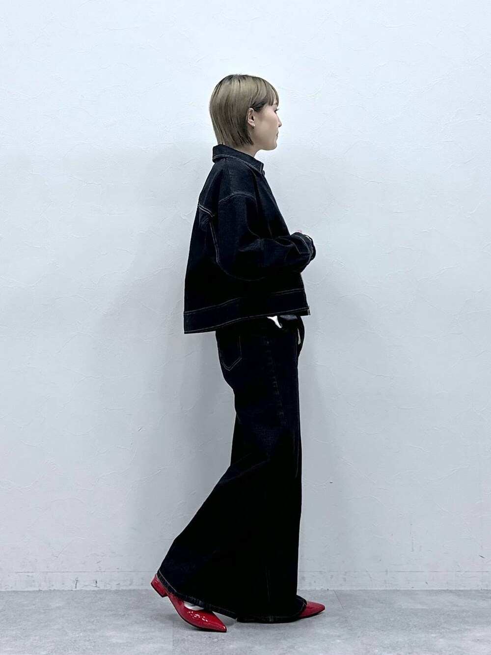 レッド系のパンプス、ブラック系のデニムジャケット、ブラック系のデニムパンツを着用したレディースの冬コーディネートの4枚目の写真