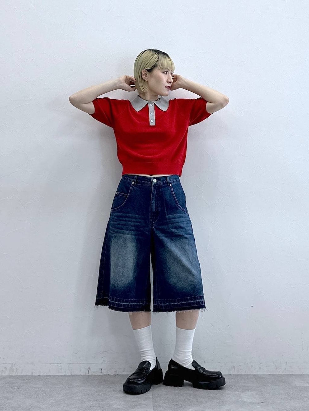 ブルー系のデニムパンツ、ブラック系のローファー、レッド系のポロシャツを着用したレディースの夏コーディネートの2枚目の写真