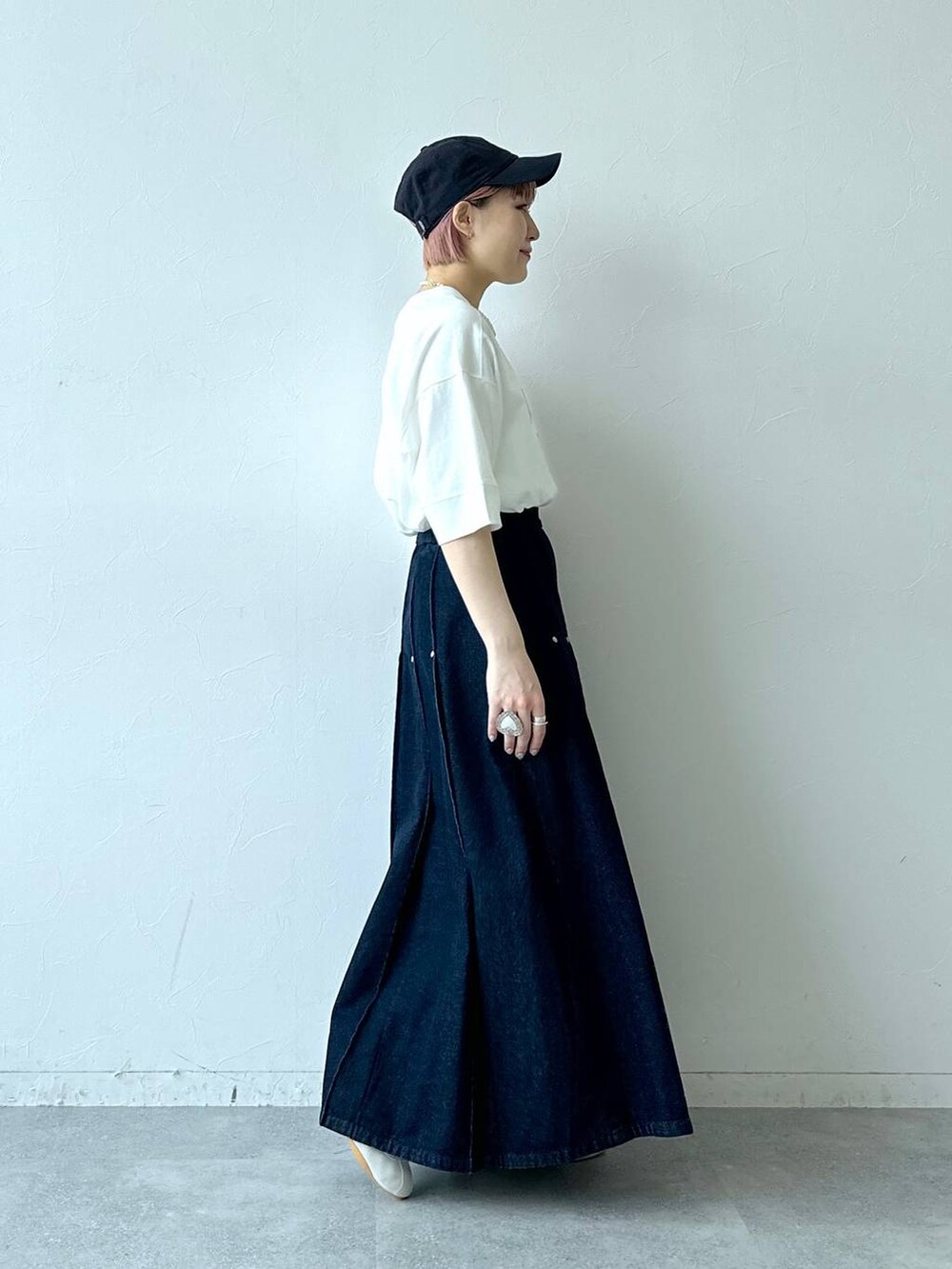 ホワイト系のTシャツ/カットソー、ホワイト系のスニーカー、ブルー系のデニムスカートを着用したレディースの春コーディネートの7枚目の写真