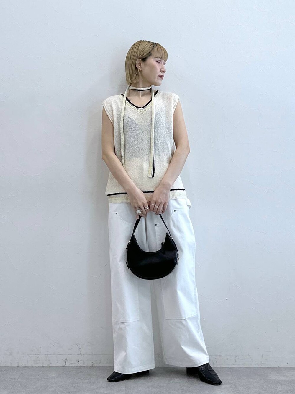 ホワイト系のニット/セーター、ホワイト系のチノパンツを着用したレディースの夏コーディネートの2枚目の写真