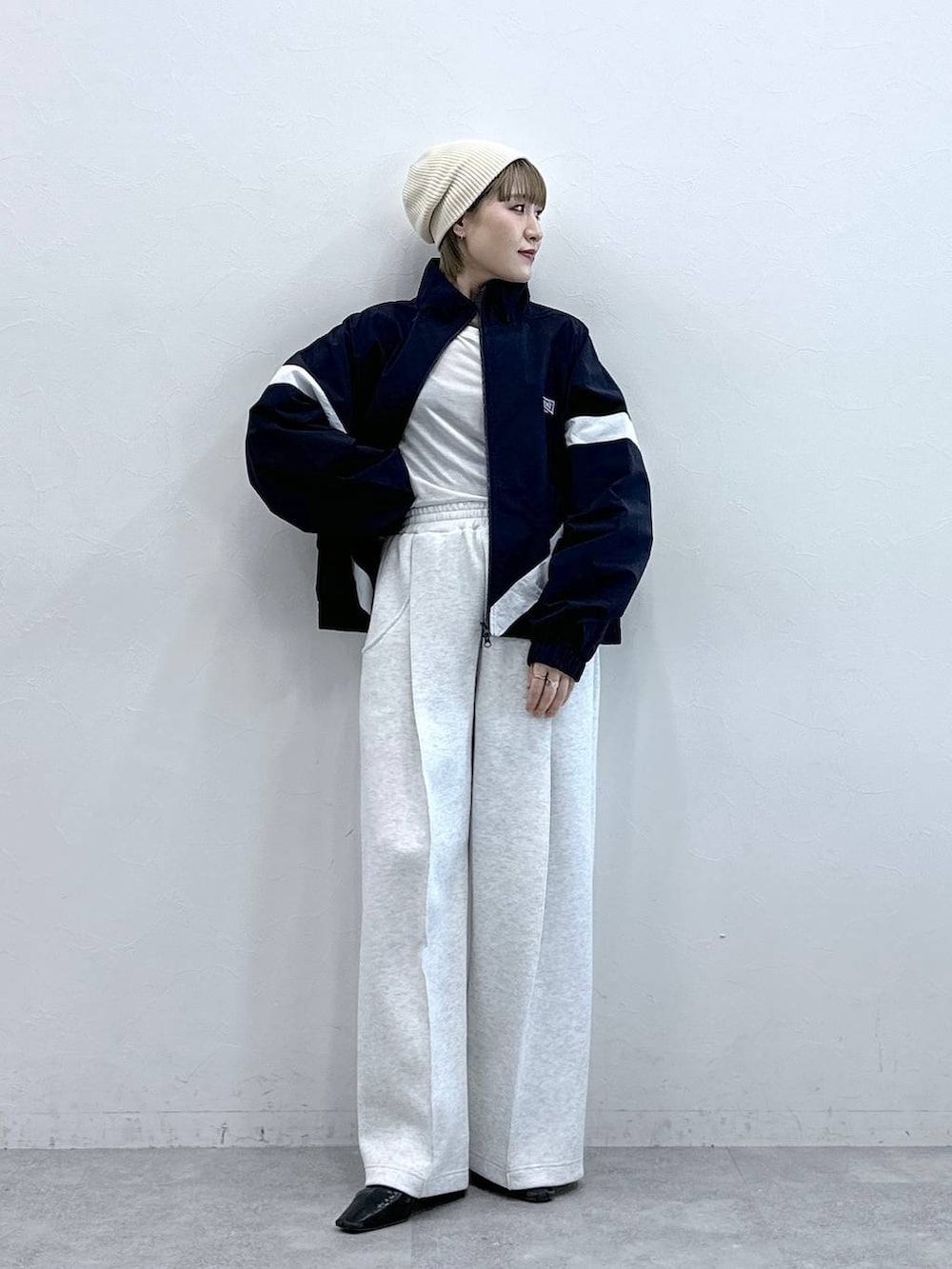 ホワイト系のスウェットパンツ、ブルー系のブルゾン、ホワイト系のTシャツ/カットソーを着用したレディースの冬コーディネートの3枚目の写真