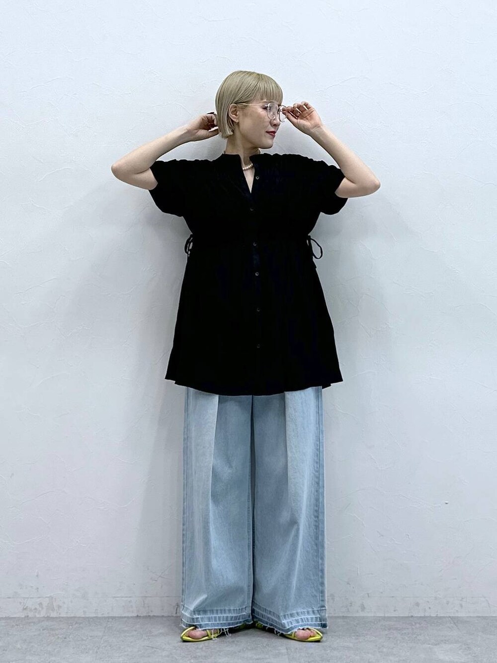 ブルー系のデニムパンツ、ブラック系のシャツ/ブラウス、ブラック系のメガネを着用したレディースの夏コーディネートの4枚目の写真