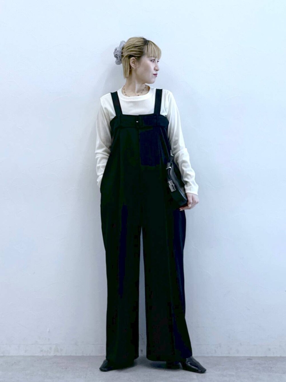 ブラック系のサロペット/オーバーオール、ホワイト系のTシャツ/カットソーを着用したレディースの冬コーディネートの2枚目の写真
