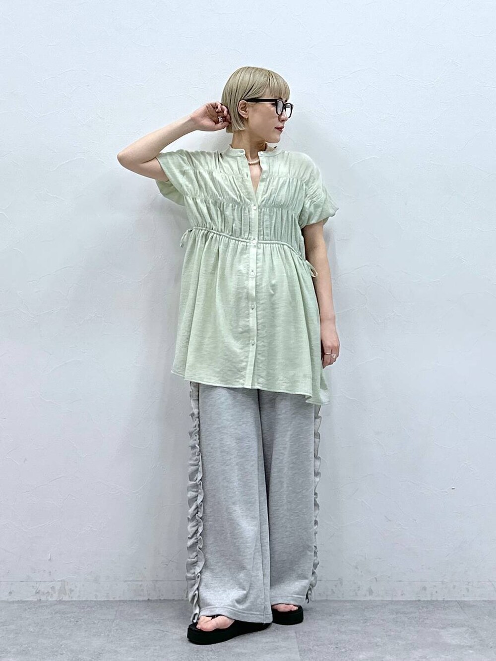 グレー系のスウェットパンツ、グリーン系のシャツ/ブラウス、ブラック系のサンダルを着用したレディースの夏コーディネートの5枚目の写真