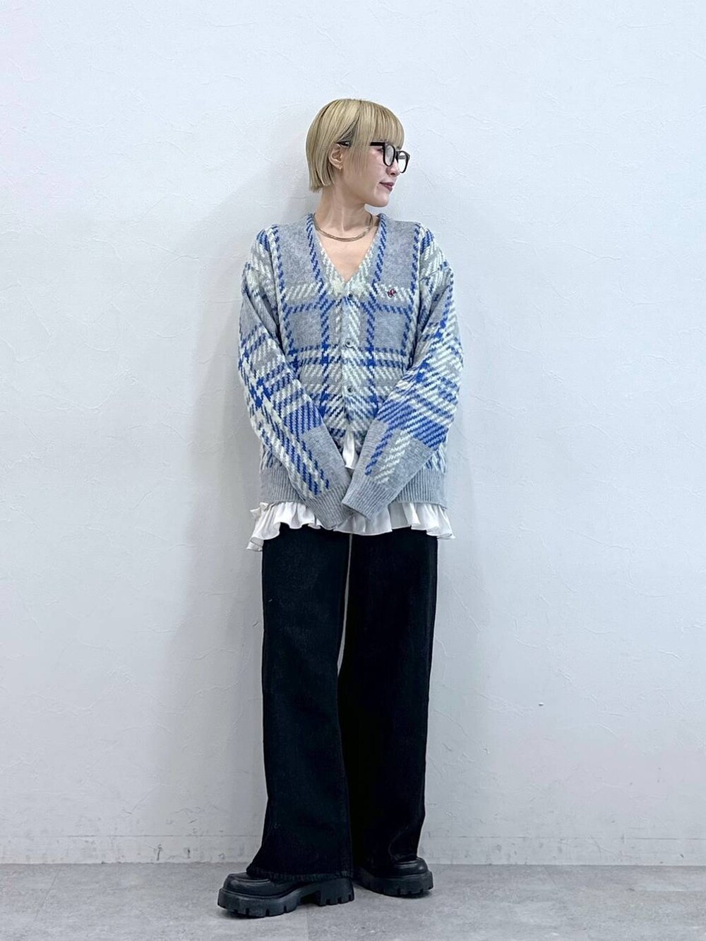 ブラック系のデニムパンツ、ブラック系のローファー、グレー系のニット/セーターを着用したレディースの秋コーディネートの3枚目の写真