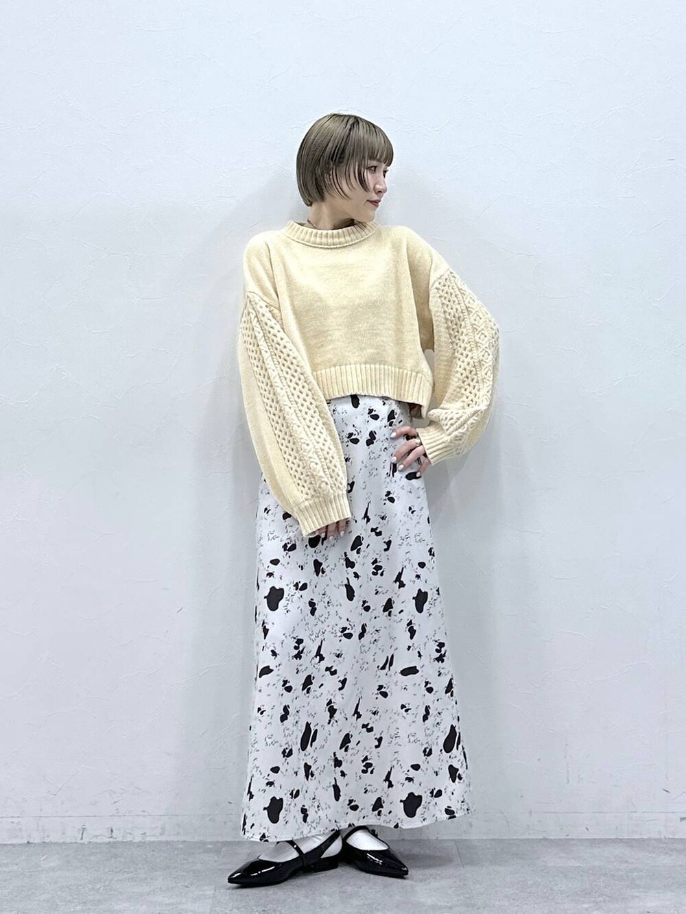 ホワイト系のニット/セーター、ブラウン系のスカート、ブラック系のパンプスを着用したレディースの冬コーディネートの3枚目の写真