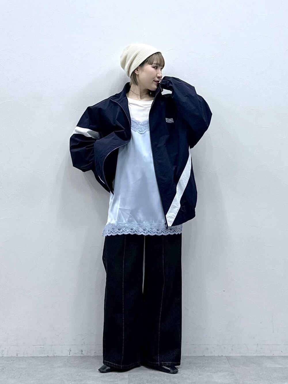 ブルー系のブルゾン、ブラック系のデニムパンツ、ブルー系のキャミソールを着用したレディースの冬コーディネートの2枚目の写真