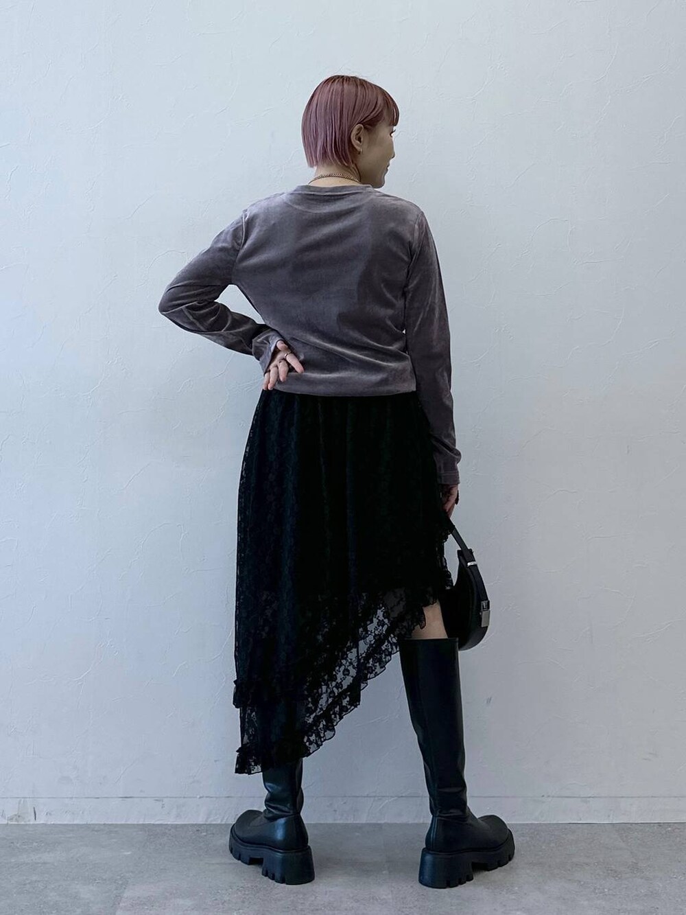 ブラック系のブーツ、パープル系のTシャツ/カットソー、ブラック系のスカートを着用したレディースの冬コーディネートの5枚目の写真