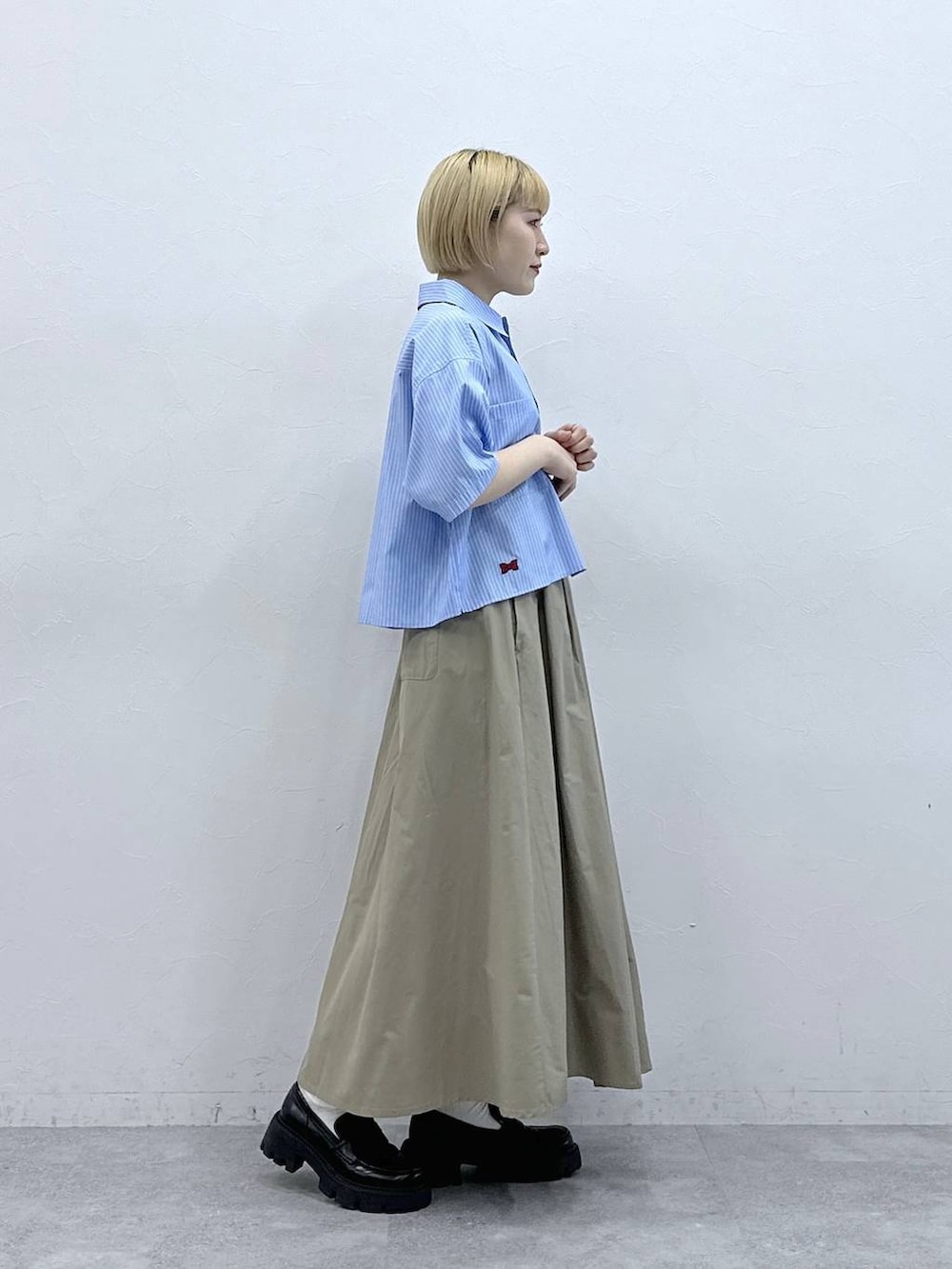 ブラック系のローファー、ブルー系のシャツ/ブラウス、ベージュ系のスカートを着用したレディースの春コーディネートの4枚目の写真