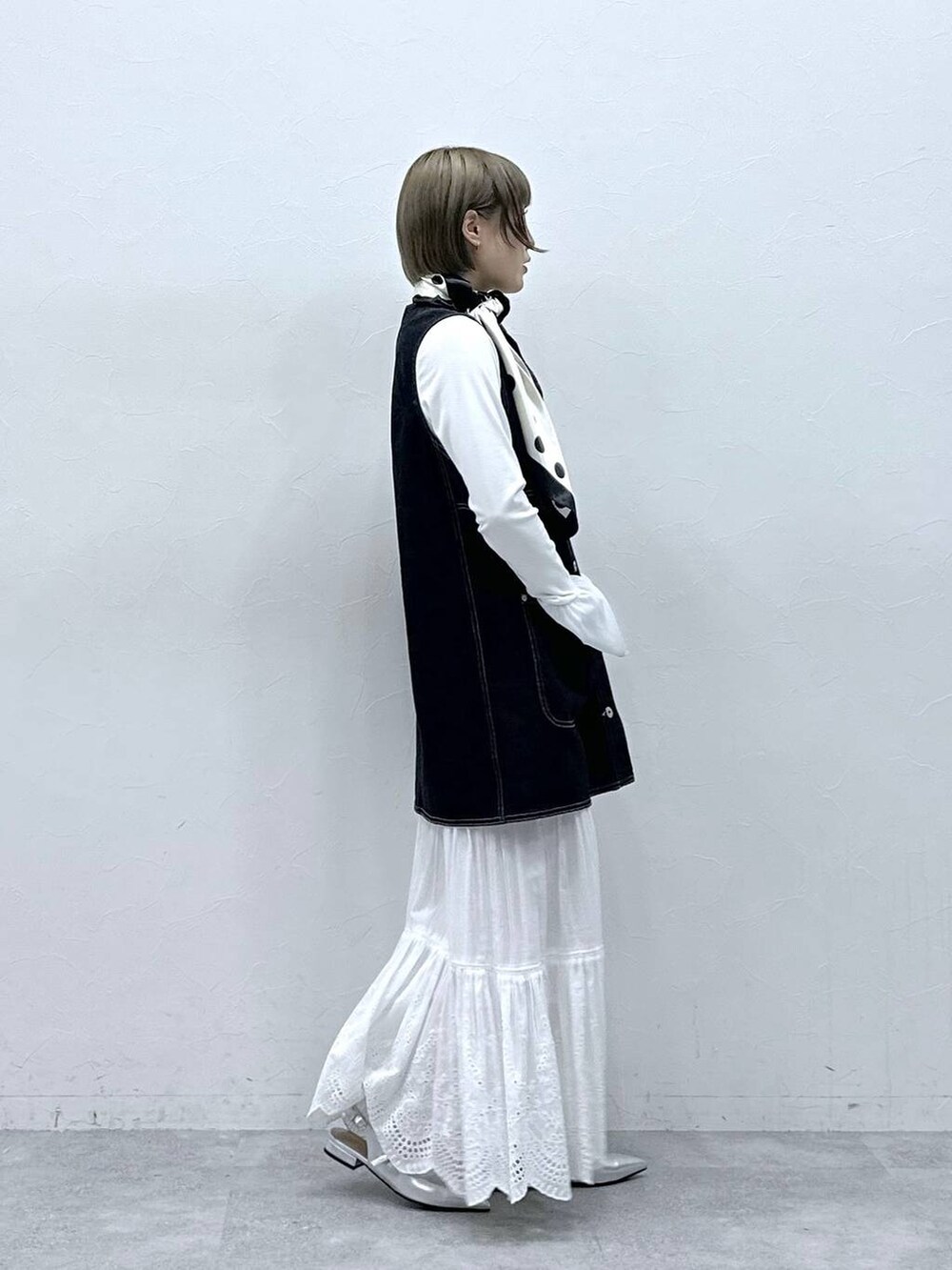 シルバー系のパンプス、ブラック系のワンピース、ホワイト系のTシャツ/カットソーを着用したレディースの冬コーディネートの6枚目の写真