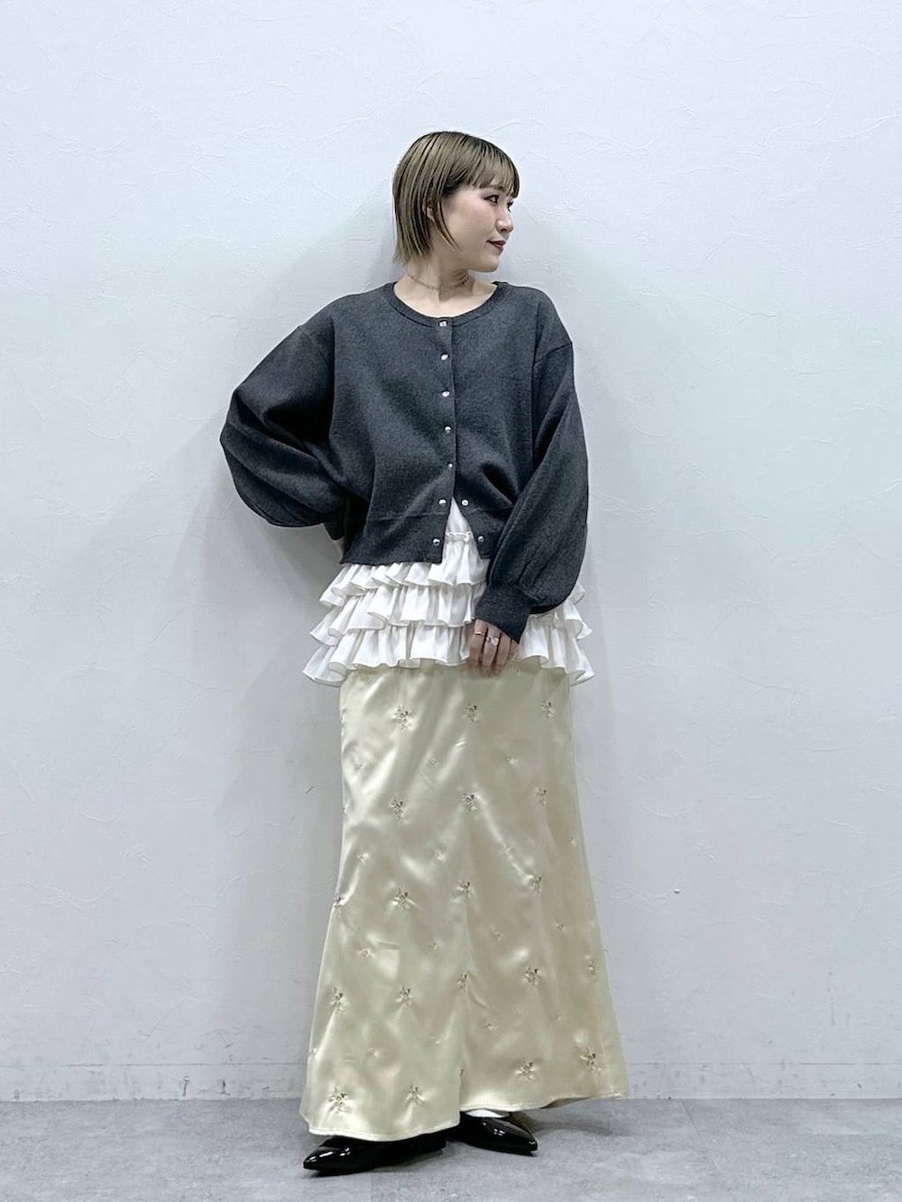 ホワイト系のキャミソール、ブラック系のパンプス、グレー系のカーディガン/ボレロを着用したレディースの冬コーディネートの2枚目の写真