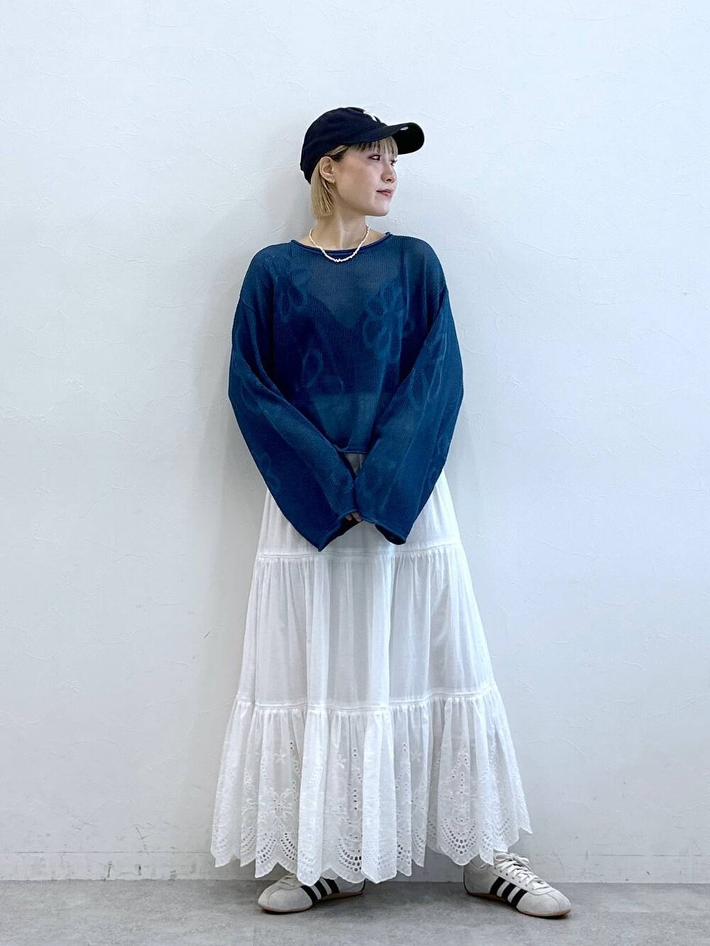 ホワイト系のスニーカー、ホワイト系のスカート、ブルー系のニット/セーターを着用したレディースの夏コーディネートの3枚目の写真