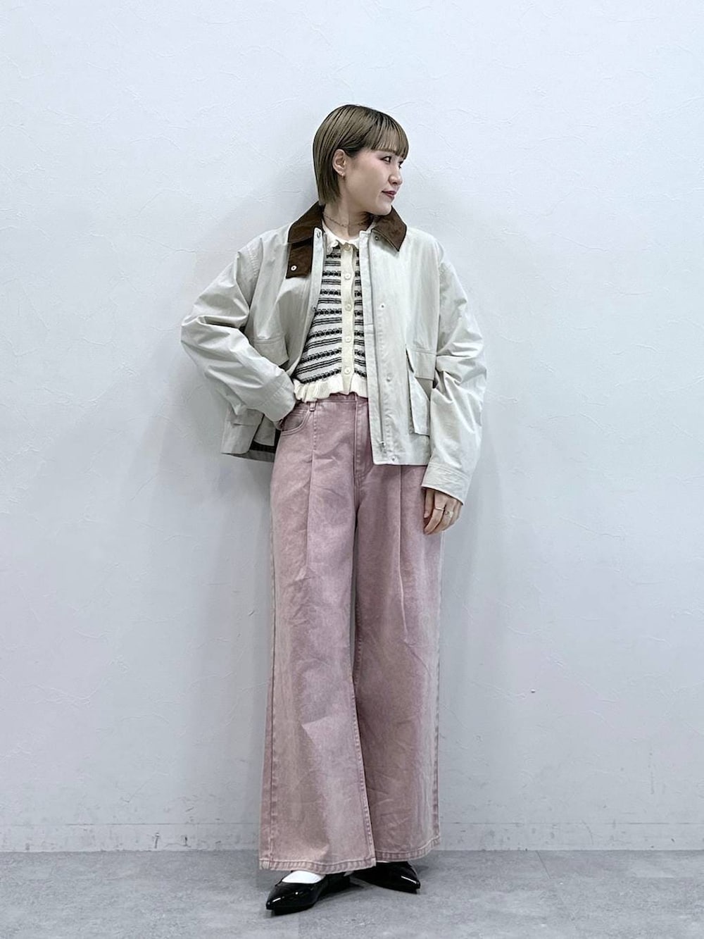 ブラック系のパンプス、ピンク系のデニムパンツ、ホワイト系のブルゾンを着用したレディースの冬コーディネートの2枚目の写真