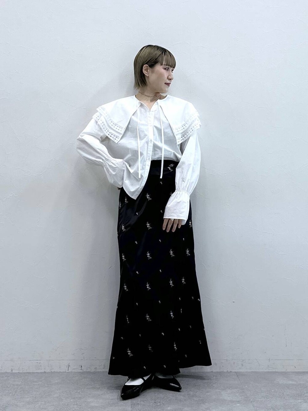 ホワイト系のシャツ/ブラウス、ブラック系のパンプス、ブラック系のスカートを着用したレディースの冬コーディネートの3枚目の写真