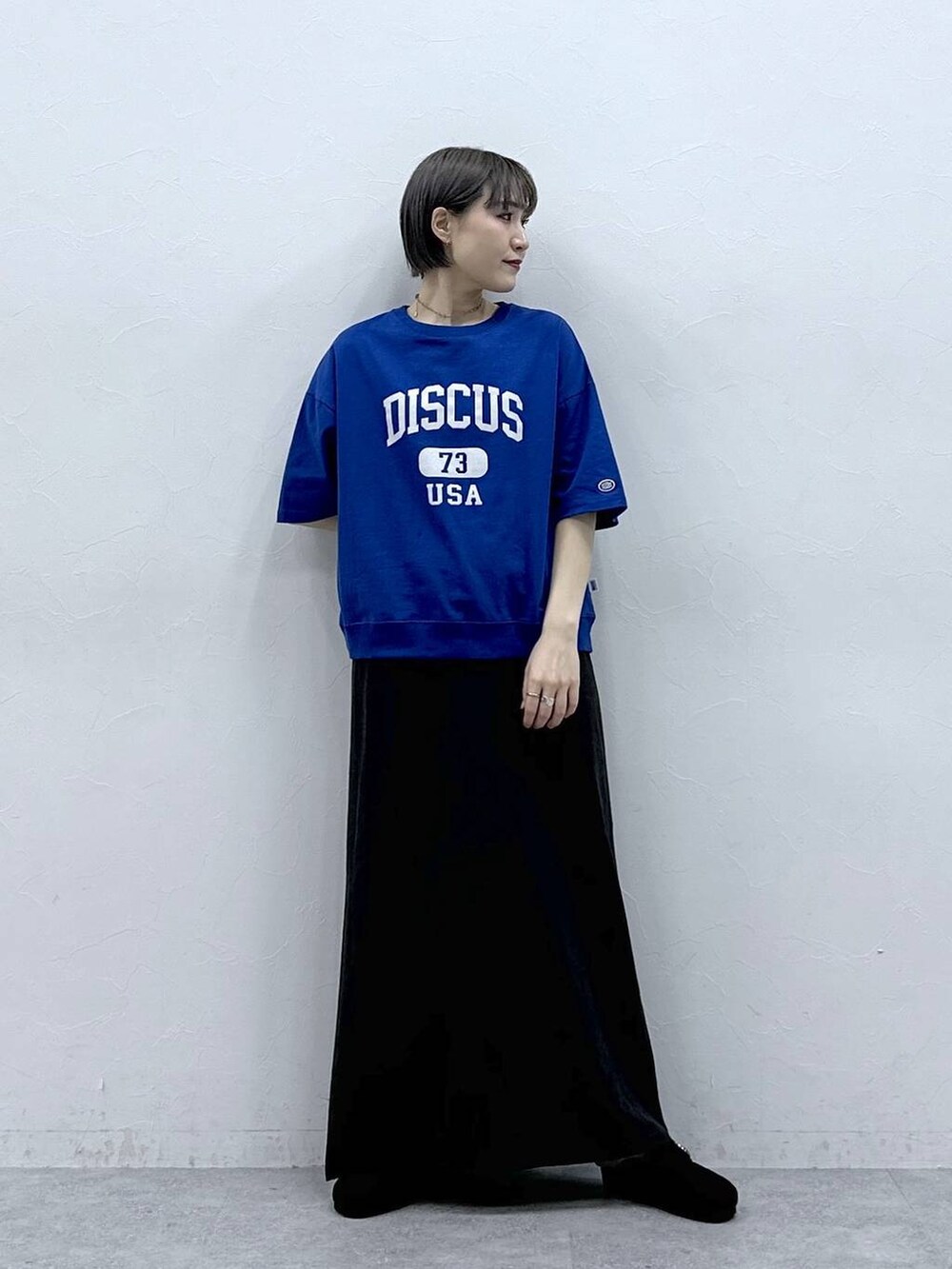 ブルー系のTシャツ/カットソー、ブラック系のモカシン/デッキシューズ、ブラック系のスカートを着用したレディースの春コーディネートの3枚目の写真