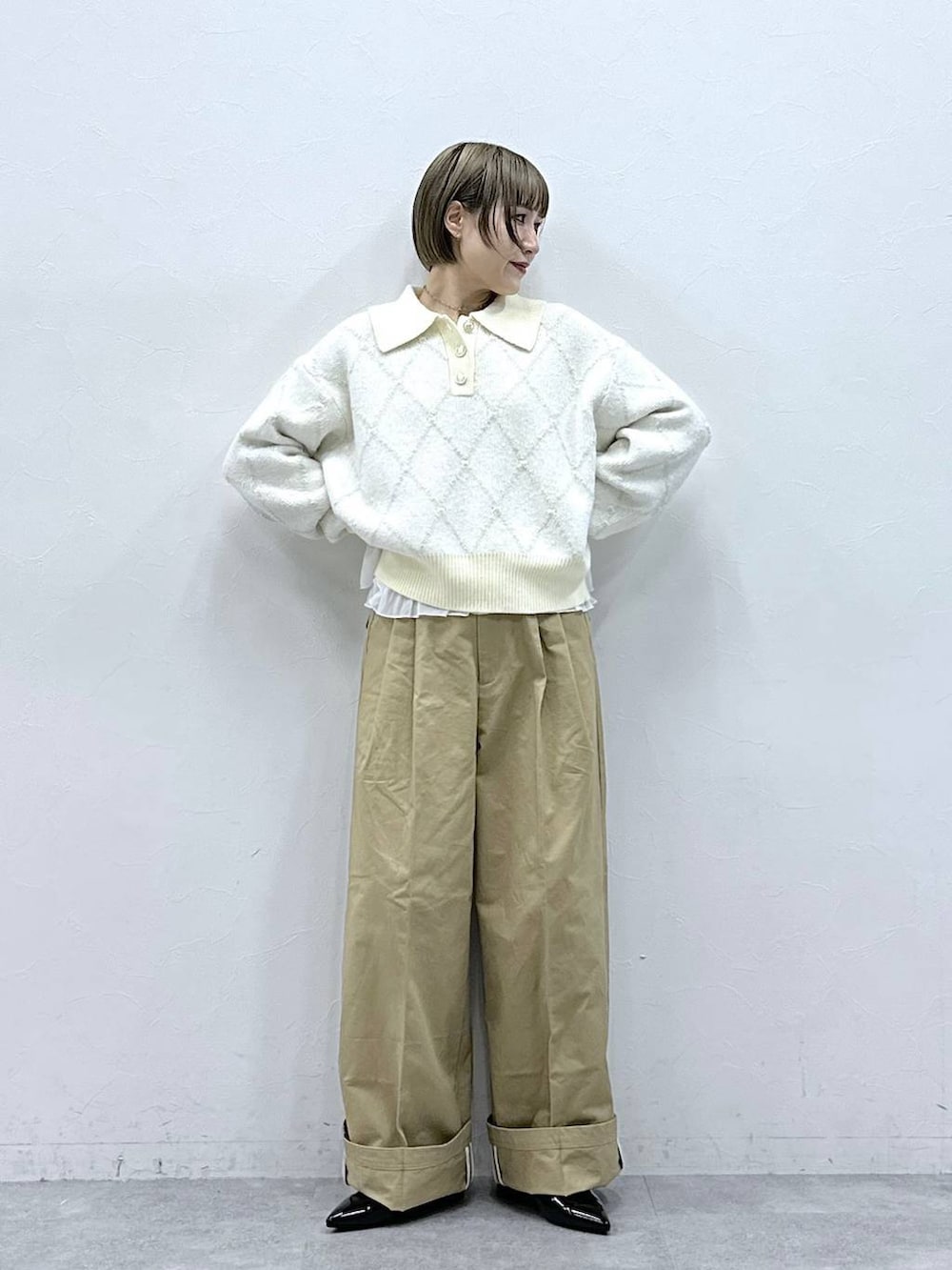 ブラック系のパンプス、ホワイト系のTシャツ/カットソー、ベージュ系のチノパンツを着用したレディースの冬コーディネートの2枚目の写真