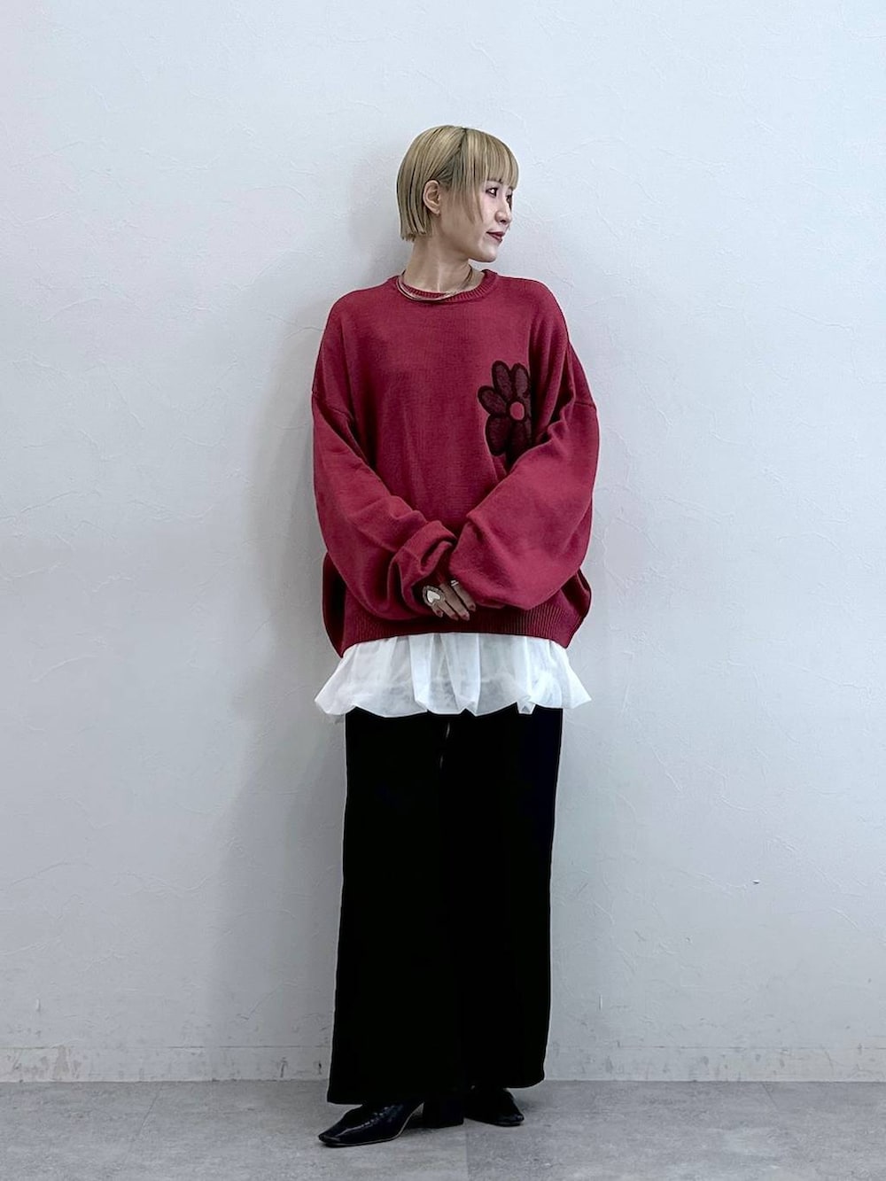 ブラック系のテーラードジャケット、ピンク系のニット/セーター、ホワイト系のスカートを着用したレディースの秋コーディネートの2枚目の写真