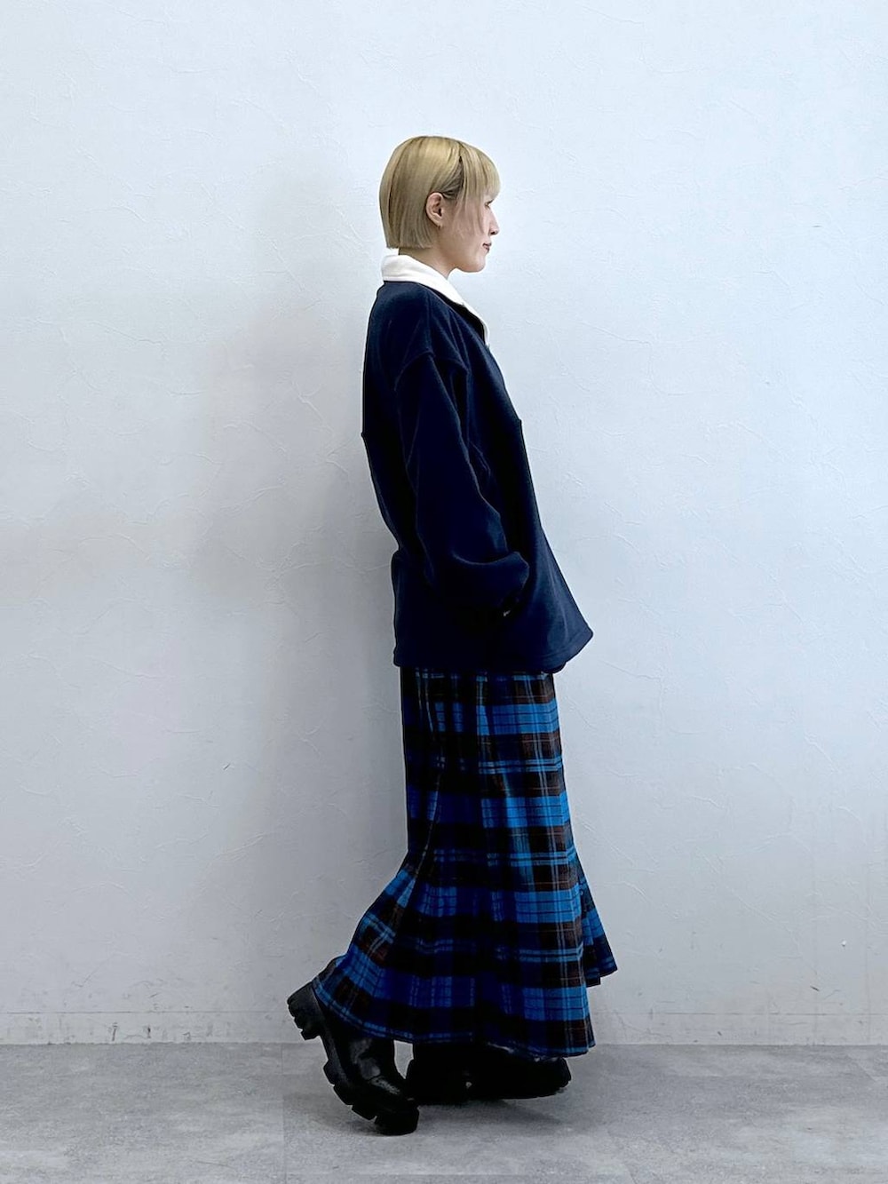 ブルー系のスウェット、ブラック系のブーツ、ブルー系のスカートを着用したレディースの秋コーディネートの6枚目の写真