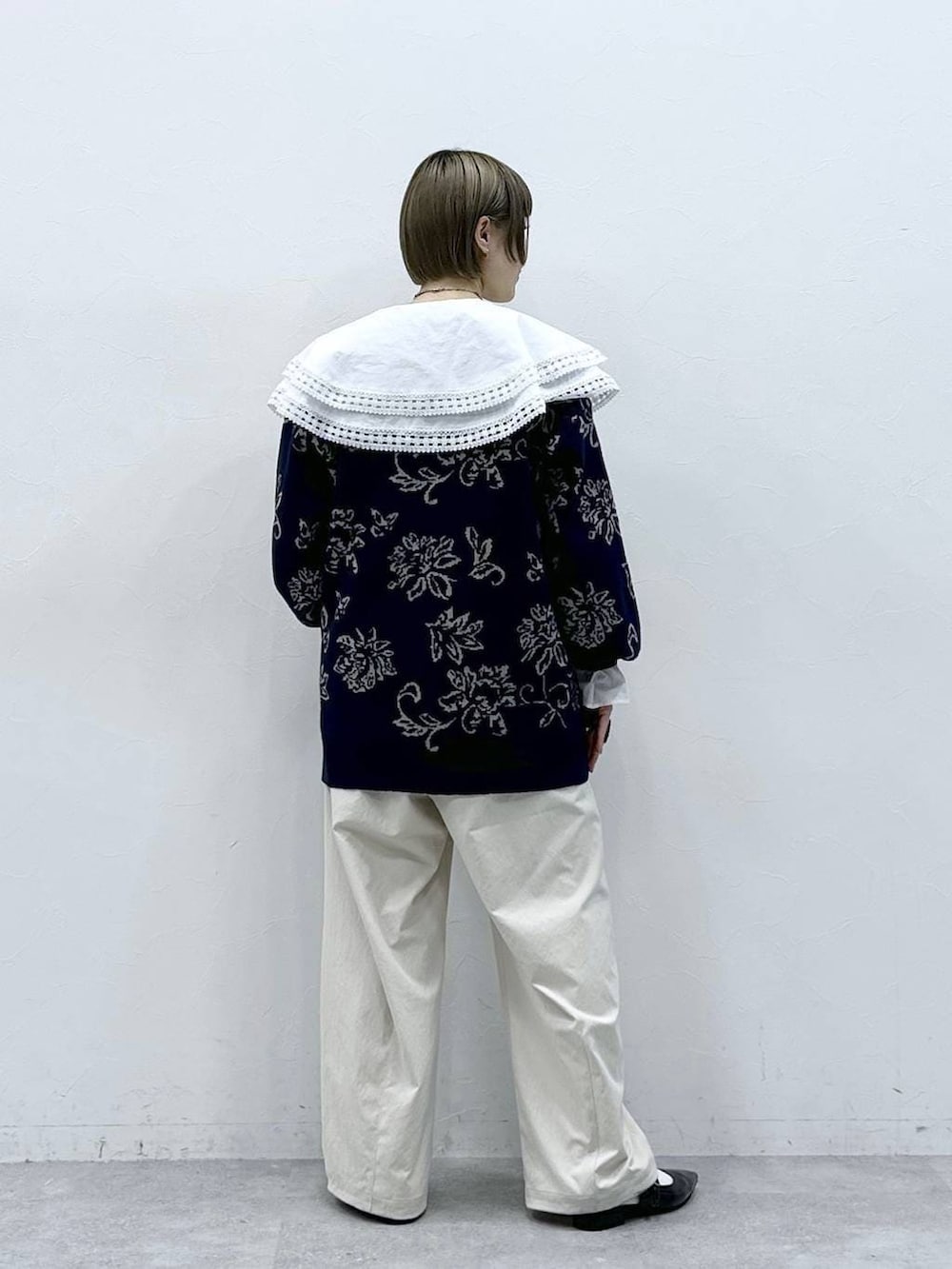 ホワイト系のチノパンツ、ホワイト系のシャツ/ブラウス、ブルー系のニット/セーターを着用したレディースの冬コーディネートの6枚目の写真