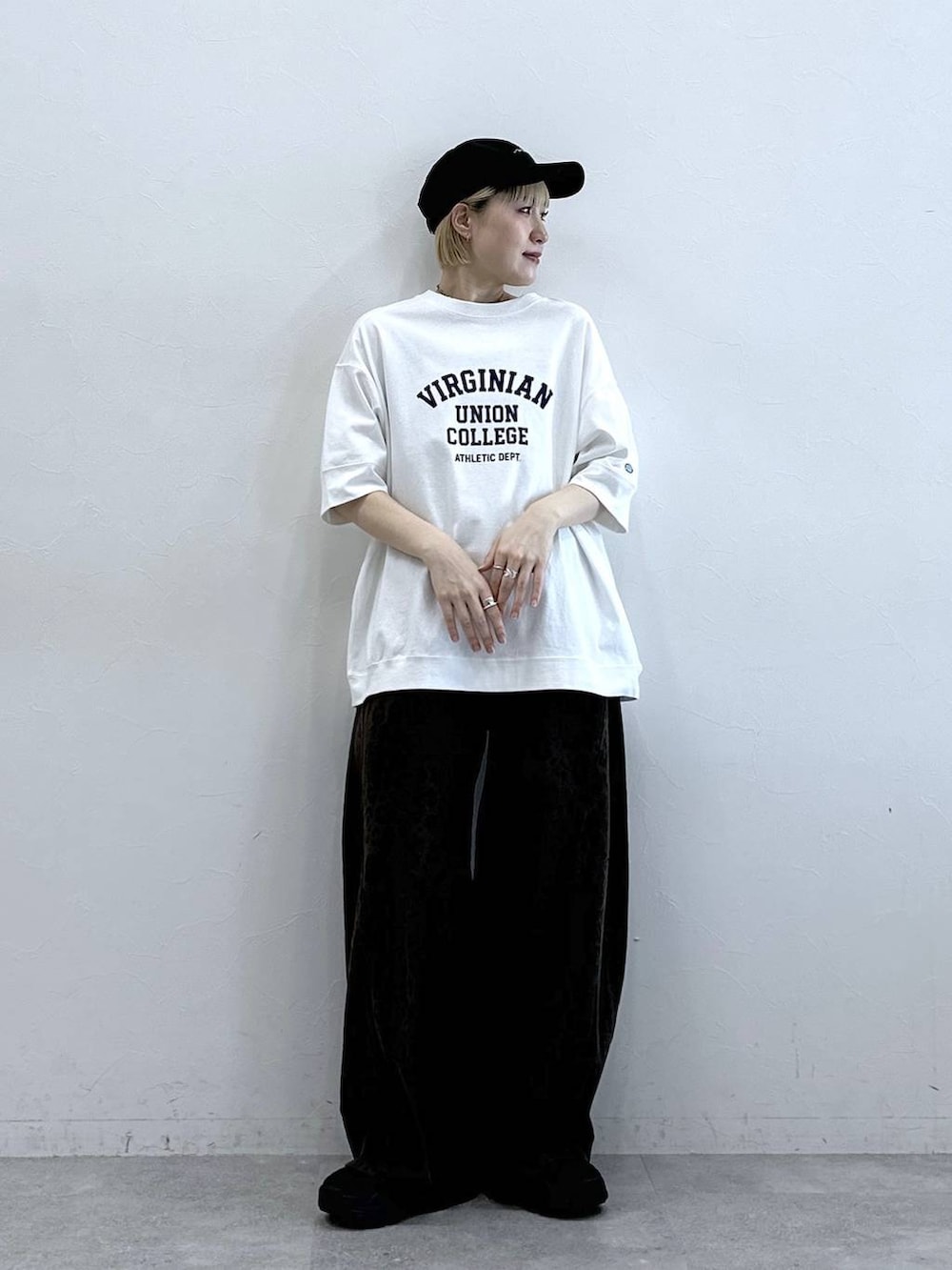ホワイト系のTシャツ/カットソー、ブラック系のサンダル、ブラウン系のデニムパンツを着用したレディースの春コーディネートの2枚目の写真