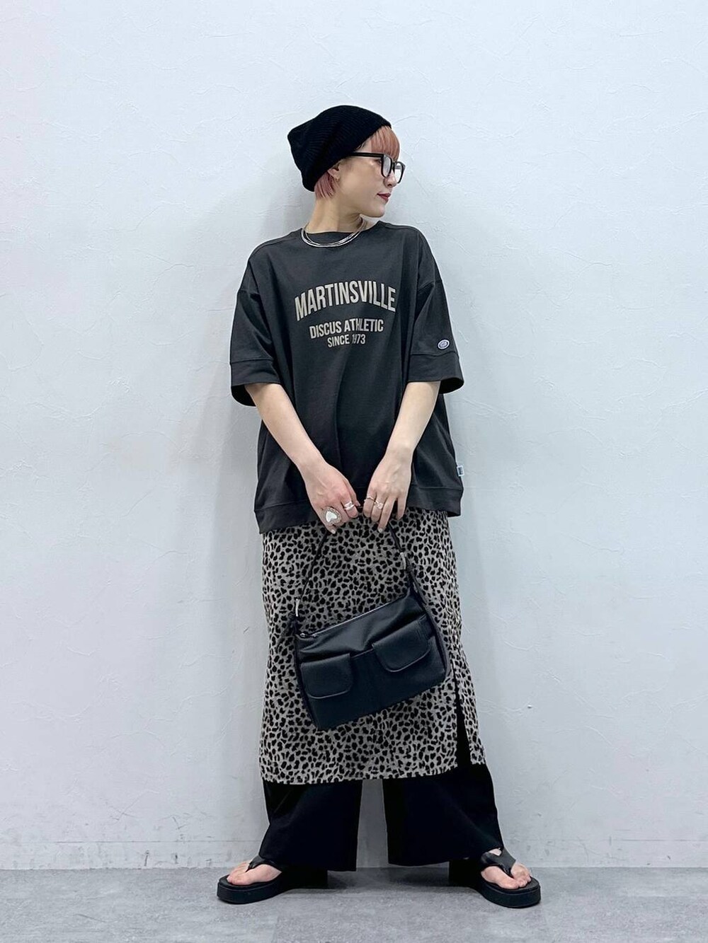 ブラック系のスラックス、グレー系のTシャツ/カットソー、ベージュ系のスカートを着用したレディースの春コーディネートの3枚目の写真