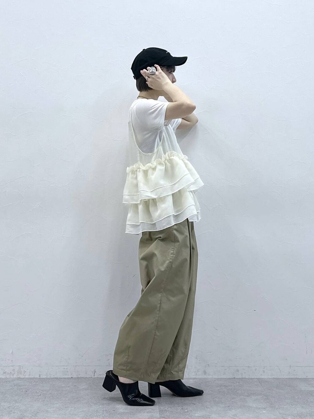 ベージュ系のチノパンツ、ホワイト系のTシャツ/カットソー、ホワイト系のベストを着用したレディースの春コーディネートの4枚目の写真