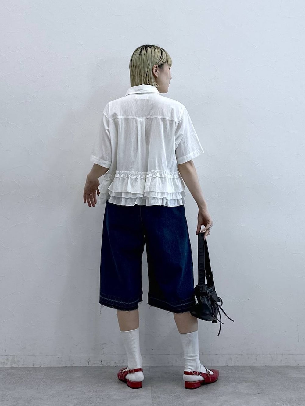 ブルー系のデニムパンツ、ブラック系のショルダーバッグ、レッド系のパンプスを着用したレディースの夏コーディネートの5枚目の写真