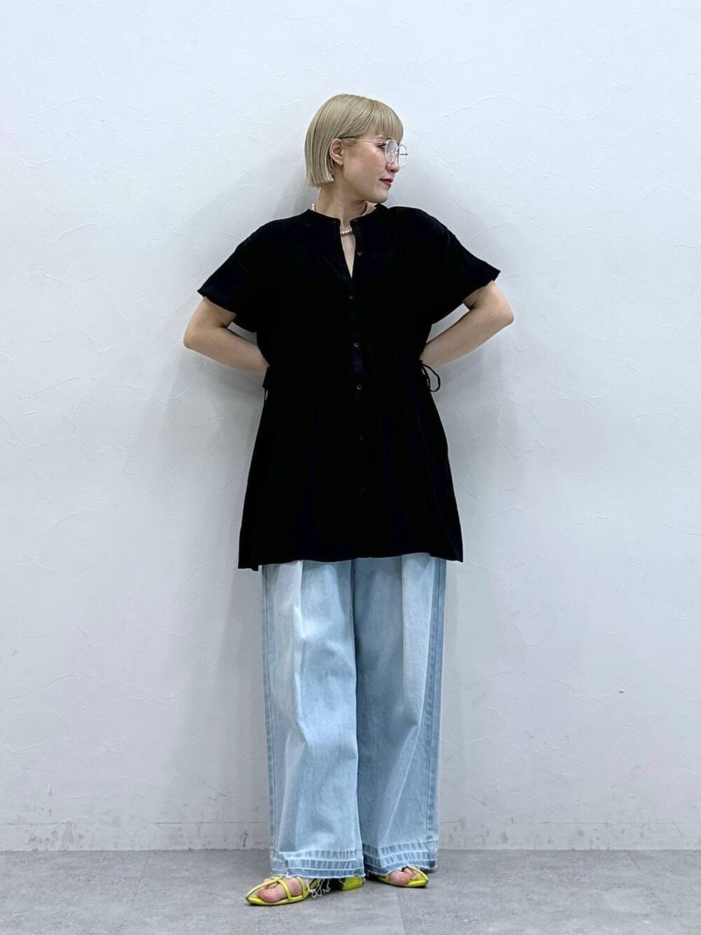 ブルー系のデニムパンツ、ブラック系のシャツ/ブラウス、ブラック系のメガネを着用したレディースの夏コーディネートの2枚目の写真