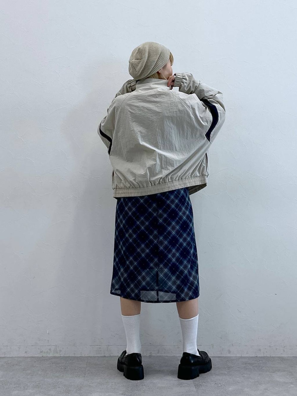 ブラック系のローファー、ブルー系のスカート、ホワイト系のブルゾンを着用したレディースの夏コーディネートの7枚目の写真