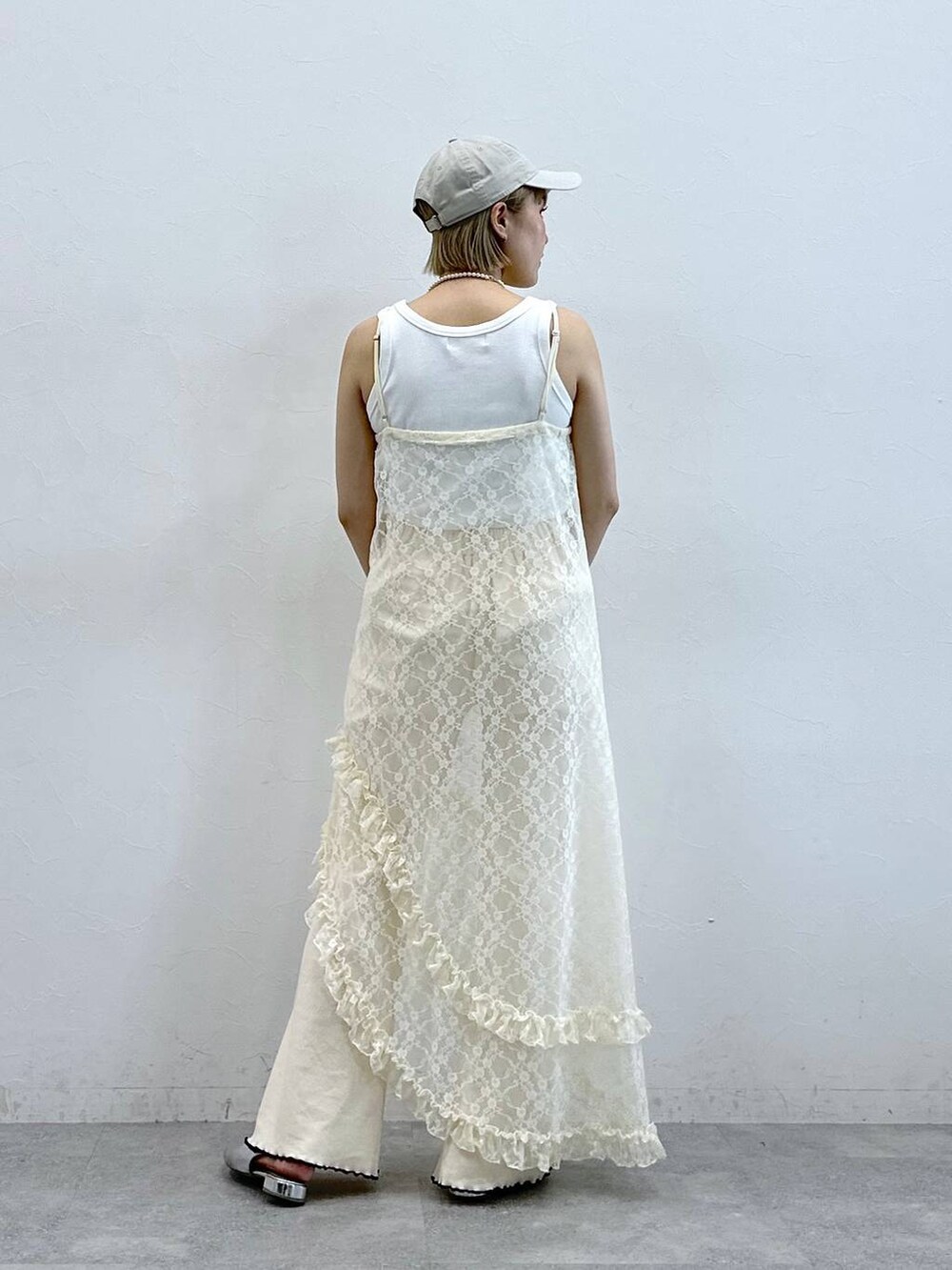 ホワイト系のタンクトップ、ホワイト系のスウェットパンツ、ホワイト系のワンピースを着用したレディースの夏コーディネートの5枚目の写真