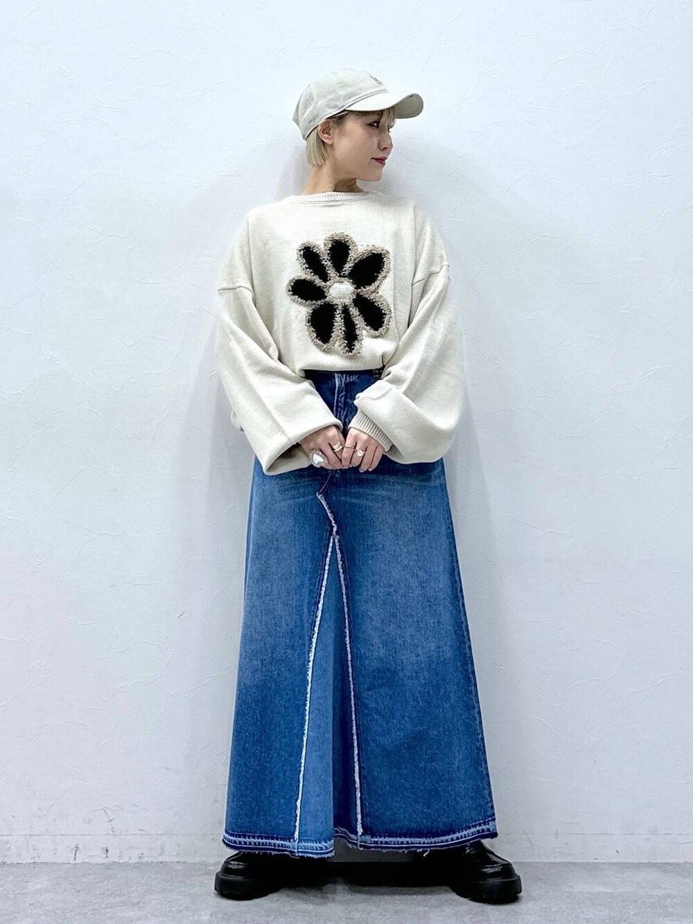 ブルー系のデニムスカート、ホワイト系のニット/セーター、ブラック系のローファーを着用したレディースの冬コーディネートの2枚目の写真