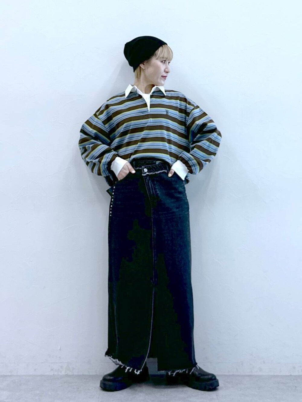 ブラック系のブーツ、ブラック系のデニムスカート、ブラウン系のポロシャツを着用したレディースの冬コーディネートの4枚目の写真