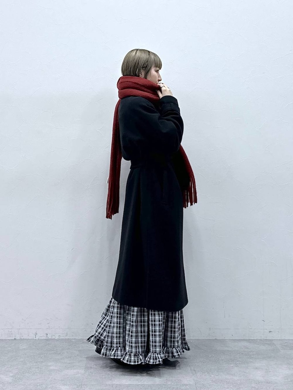 ブラック系のステンカラーコート、ブラック系のスカート、ブラック系のパンプスを着用したレディースの冬コーディネートの4枚目の写真