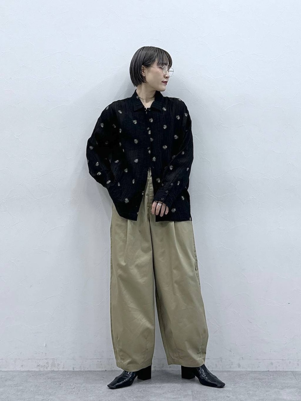 ベージュ系のチノパンツ、ブラック系のシャツ/ブラウスを着用したレディースの春コーディネートの3枚目の写真